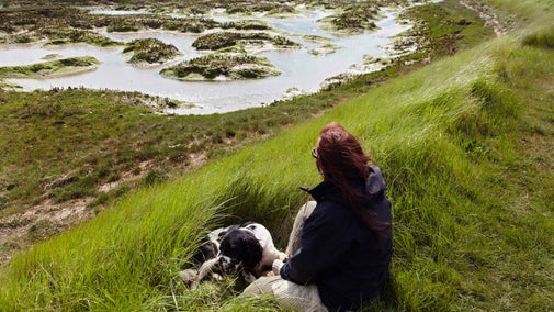 Woman with a dog at Copt Hall Marshes, Essex